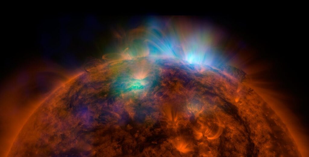 A close-up photograph of the Sun showing active regions and solar prominences.